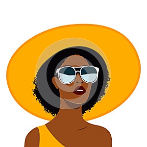 Portrait of a young beautiful black woman in yellow beach outfit wide brimmed sun hat and one-shoulder dress. Fashion summer