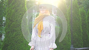 Portrait of a young beautiful blind woman in a hijab with a cane outside on a Sunny day