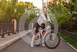 Portrait of young beautiful blonde girl with bicycle