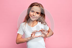 Portrait of young beautiful blonde girl making heart with palms