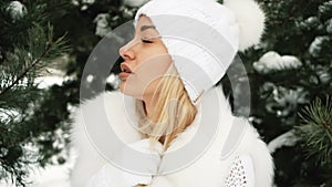 Portrait of young beautiful blonde in winter forest.