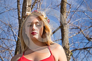 Portrait of young, beautiful, blonde woman with a red dress and flower tiara, calm and relaxed. Concept beauty, fashion, spring,