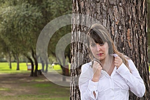 Portrait of young, beautiful, blonde woman in white shirt clutching the lapels of her shirt with seductive look and leaning on the photo