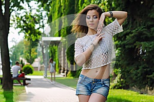 Portrait of young beautiful brunette woman in blue jeans short