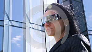 Portrait of young beautiful business woman student in suit, future glasses, smiling, successful looking at sides, with skyscrape