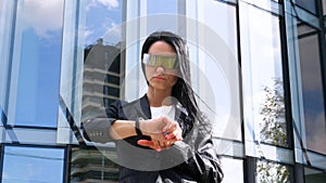 Portrait of young beautiful business woman student in suit, future glasses, smiling, successful looking at sides, with skyscrape