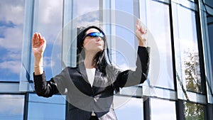 Portrait of young beautiful business woman student in suit, future glasses, smiling, successful looking at sides, with skyscrape