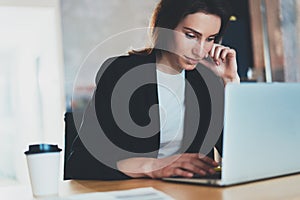Portrait of Young beautiful businesswoman using notebook computer at modern office.Blurred background.Horizontal.