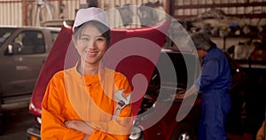 Portrait of a young beautiful car mechanic in a car workshop.