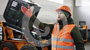 Portrait of a young beautiful car mechanic in a car workshop, in the background of service. He comes into a garage in a