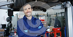 Portrait of a young beautiful car mechanic in a car workshop, in the background of service. Concept: repair of machines, fault dia photo