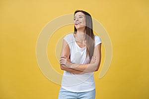 Portrait young beautiful caucasian girl with an white shirt laughing over yellow background.