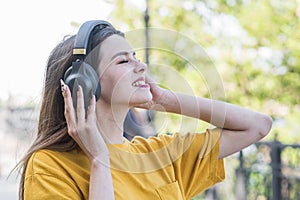 Portrait of a young and beautiful caucasian girl who listening to music with headphones.