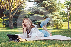 Caucasian teenage girl talking over cell mobile phone outside in park