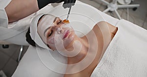 Portrait of a young beautiful Caucasian woman in a beauty salon. White face mask