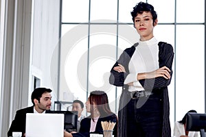 Portrait of young beautiful confident smart elegant businesswoman black short hair standing with arms crossed at modern office