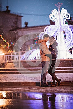 Portrait of young beautiful couple kissing in an autumn rainy day.