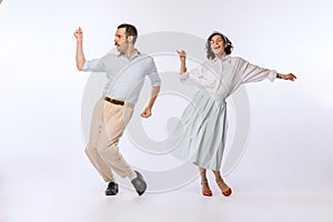 Portrait of young beautiful couple, man and woman, dancing isolated over white studio background. Dance improvisation