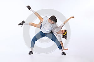 Portrait of young beautiful couple, man and woman, dancing isolated over white studio background. Extravagant dance