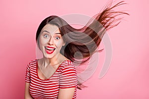 Portrait of young beautiful excited smiling good mood girl open mouth flying hair isolated on pink color background