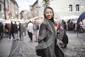 Portrait of young beautiful fashionable brunette woman posing in street at autumn.