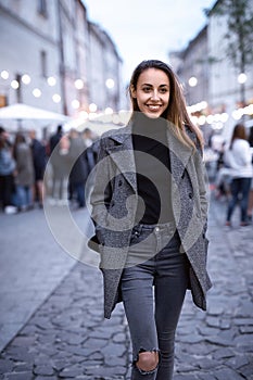 Portrait of young beautiful fashionable brunette woman posing in street at autumn.