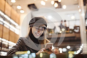 Portrait of young beautiful fashionable brunette woman sitting in coffeehouse