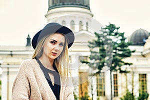 Portrait of a young beautiful fashionable woman, girl posing on the street of the old European city.