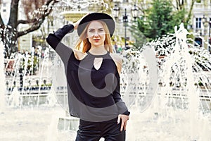 Portrait of a young beautiful fashionable woman, girl posing on the street of the old European city.