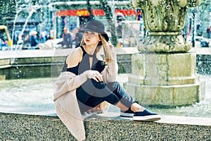 Portrait of a young beautiful fashionable woman, girl posing on the street of the old European city.