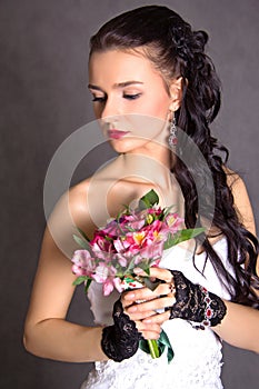 Portrait of a young beautiful fiancee with a bunch of pink flowers