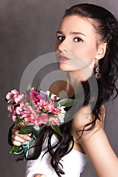 Portrait of a young beautiful fiancee with a bunch of pink flowers