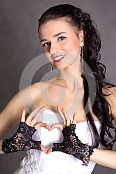 Portrait of a young beautiful fiancee showing a heart