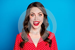 Portrait of young beautiful funky smiling positive happy girl with red lipstick lick teeth tongue isolated on blue color