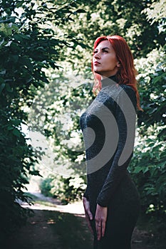 Portrait of young beautiful girl with beautiful appearance. Red-haired woman with a pretty face pose in a tight-fitting dress. A