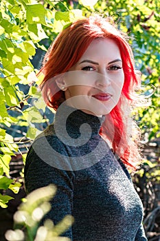 Portrait of young beautiful girl with beautiful appearance. Red-haired woman with a pretty face pose in a tight-fitting dress. A