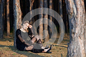 Portrait of a young beautiful girl in a black dress walking in the park.