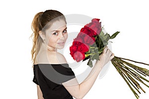 Portrait of a young beautiful girl with a bouquet of red roses