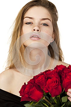 Portrait of a young beautiful girl with a bouquet of red roses