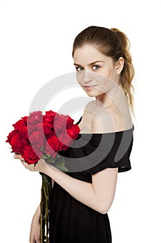 Portrait of a young beautiful girl with a bouquet of red roses