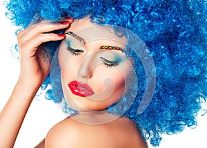 Portrait of a young beautiful girl with bright makeup in blue wi