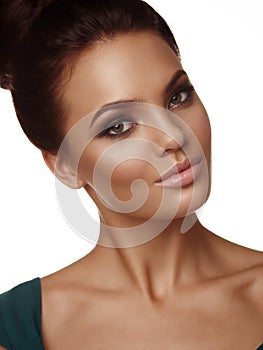 Portrait of a young beautiful girl with collected hair and expressive make up on the white background