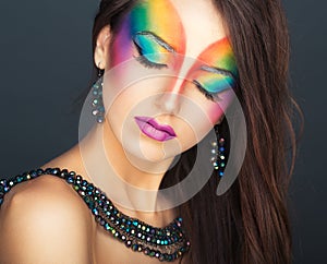 Portrait of a young beautiful girl with a fashion bright multicolored makeup