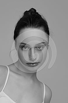 Portrait of young beautiful girl with natural makeup posing, looking at camera. Black and white photography