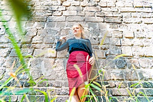 Portrait of a young and beautiful girl near a brick wall.