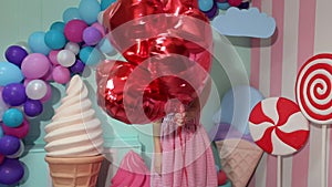 Portrait of young beautiful girl with red balloons