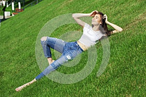 Portrait of a young beautiful girl resting on the lawn in the park