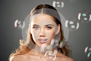 Portrait of young beautiful girl in Studio, with professional makeup.Beauty shooting.The beauty of soap bubbles. The