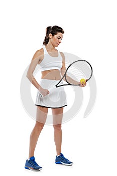 Portrait of young beautiful girl, tennis player in white sportswear posing with racket isolated on white background