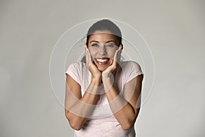 Portrait of young beautiful and happy Latin woman holding face with hands with big toothy smile